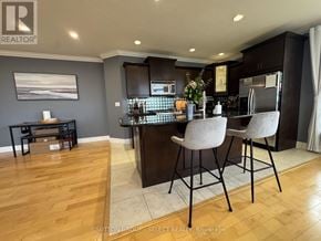London East (East F) condo for rent - A modern kitchen with dark wood cabinets and a bar area.