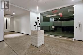 Toronto (Niagara) condo for rent - A white reception desk with a plant on top is in a room with a glass door.