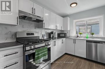 London East (East K) multi-family for rent - A modern kitchen with white cabinets and stainless steel appliances.
