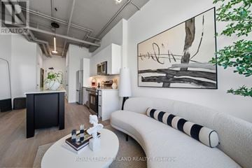London East (East F) multi-family for rent - A modern living room with a large painting on the wall and a white sofa.