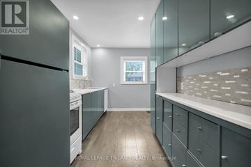 St. Thomas multi-family for rent - A modern kitchen with a black refrigerator and wooden floors.