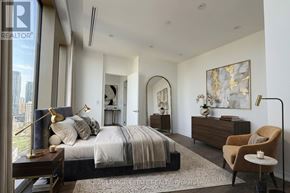 Toronto (Annex) condo for rent - A bedroom with a large bed, a chair, and a painting on the wall.