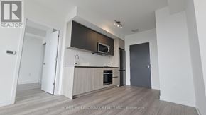 Toronto (Newtonbrook West) condo for rent - A modern kitchen with a wooden floor and white walls.