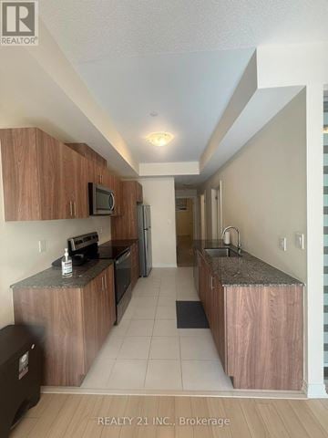Toronto (Malvern) townhouse for rent - A kitchen with wooden cabinets and a granite countertop.