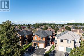 Mississauga (Hurontario) apartment for rent - A real estate company logo is displayed on a sunny day in front of a row of houses.