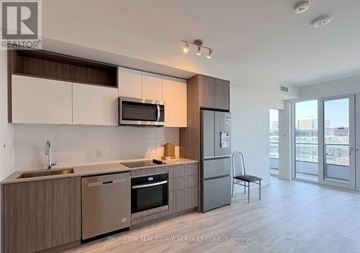 Toronto (Waterfront Communities) condo for rent - A modern kitchen with a stainless steel dishwasher and refrigerator.