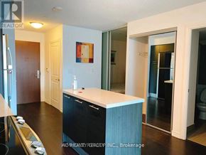 Toronto (Bay Street Corridor) condo for rent - A kitchen with a white counter top and black cabinets.