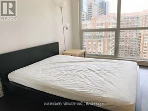 Toronto (Bay Street Corridor) condo for rent - A bedroom with a large bed and a city view through the window.