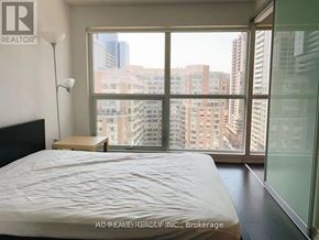 Toronto (Bay Street Corridor) condo for rent - A bedroom with a large bed and a view of the city.
