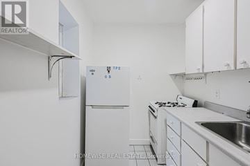 Toronto (Church-Yonge Corridor) condo for rent - A white kitchen with a refrigerator and a sink.