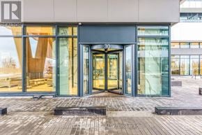 Toronto (Mimico) condo for rent - The image shows the front of a building with glass doors and windows, and a number 30 above the doors.