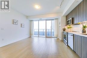 Toronto (Mimico) condo for rent - A spacious kitchen and living room with wooden floors and white walls.