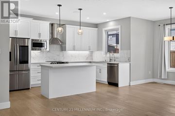 East Luther Grand Valley (Grand Valley) apartment for rent - A modern kitchen with white cabinets and a large island.