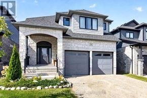 East Luther Grand Valley (Grand Valley) apartment for rent - A modern house with a grey garage door and a stone facade.