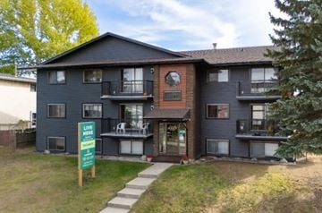 Edmonton apartment for rent - A two-story apartment building with a sign in front that says "Live Here".