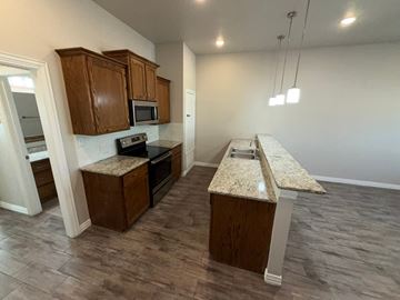 Temple townhouse for rent - A kitchen with wooden cabinets and granite countertops.