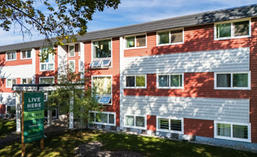 Edmonton apartment for rent - A red and white building with a sign that says "Live Here Vacancy".