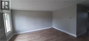Kitchener apartment for rent - A large empty room with wooden floors and white walls.