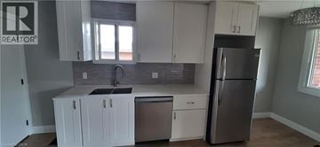 Kitchener apartment for rent - A kitchen with white cabinets and a stainless steel refrigerator.