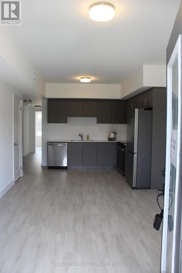 Guelph (Clairfields/Hanlon Business Park) townhouse for rent - A modern kitchen with dark wood cabinets and stainless steel appliances.