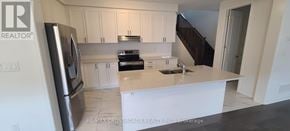 Pickering apartment for rent - A kitchen with white cabinets and a stainless steel refrigerator.