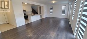 Pickering apartment for rent - A spacious room with wooden flooring and white walls, with a logo that reads "REALTOR" in the top left corner.