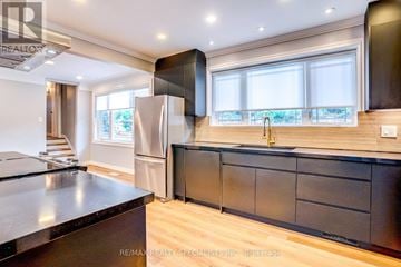 Burlington (Brant) apartment for rent - A modern kitchen with dark wood cabinets and a stainless steel refrigerator.