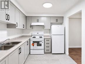 Toronto (Parkwoods-Donalda) condo for rent - A white kitchen with a stove, sink, and refrigerator.