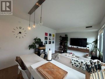 Toronto (Waterfront Communities) condo for rent - A living room with a white table and a clock on the wall.
