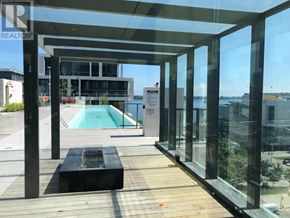 Toronto (Waterfront Communities) condo for rent - A glass-walled building with a pool in the foreground.