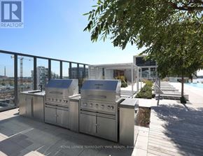 Toronto (Waterfront Communities) condo for rent - A barbecue grill is on a patio with a pool in the background.