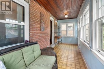 St. Catharines (Downtown) apartment for rent - A living room with a green couch and a brick wall.