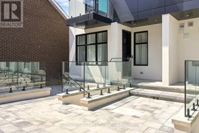 Toronto (Oakwood Village) townhouse for rent - A modern building with a glass entrance and a brick wall with the letters "R" on it.