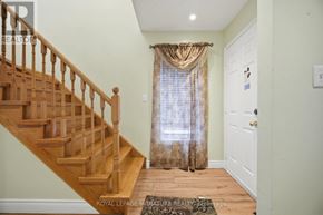 Brampton (Sandringham-Wellington) apartment for rent - A hallway with a wooden staircase and a white door.
