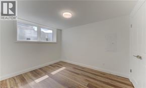 Kitchener apartment for rent - A room with wooden flooring and a white door.