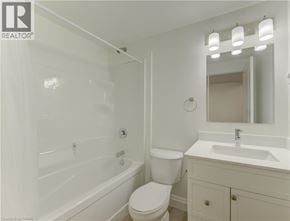 Kitchener apartment for rent - A white bathroom with a toilet, sink, and bathtub.