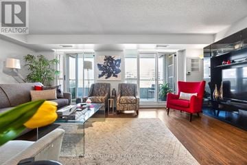 Toronto (Englemount-Lawrence) condo for rent - A living room with a glass table and a red chair.