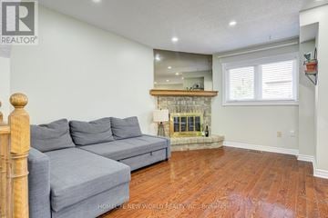 Ajax (Central West) apartment for rent - A living room with a grey couch and a fireplace.