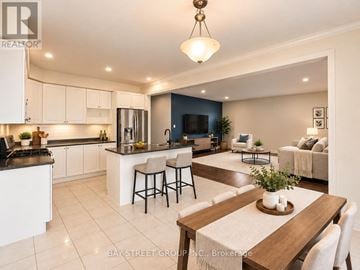 New Tecumseth apartment for rent - A well-lit kitchen and living room with a dining table set for two.