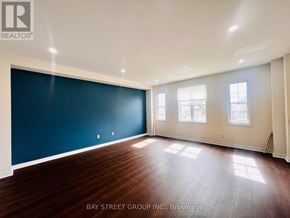 New Tecumseth apartment for rent - A room with wooden flooring and a large blue wall.