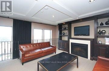 Mississauga (City Centre) condo for rent - A living room with a brown leather couch and a fireplace.