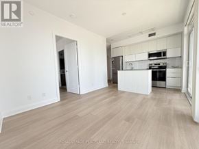 Toronto (Mimico) condo for rent - A spacious kitchen with white cabinets and a wooden floor.