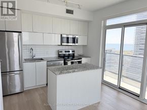 Toronto (Mimico) condo for rent - A kitchen with white cabinets and a granite countertop.