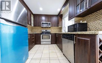 Brampton (Brampton East) apartment for rent - A kitchen with a blue refrigerator and wooden cabinets.