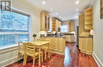 Toronto (Church-Yonge Corridor) townhouse for rent - A kitchen with wooden cabinets and a table with chairs.