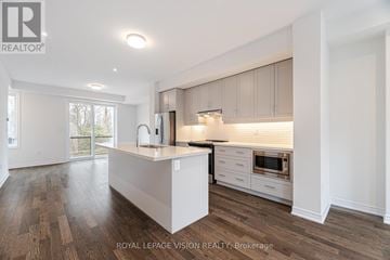 Brampton (Credit Valley) townhouse for rent - A modern kitchen with white cabinets and a wooden floor.