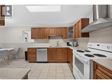 Burnaby apartment for rent - A kitchen with wooden cabinets and white appliances.