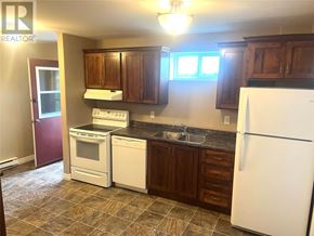 St. John's apartment for rent - A kitchen with a white fridge, white oven, and brown cabinets.