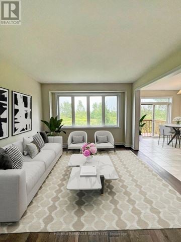 Welland (Dain City) apartment for rent - A living room with a white couch and a coffee table with a vase of flowers on it.