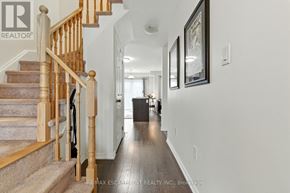 Brantford townhouse for rent - A hallway with a staircase and a framed picture on the wall.